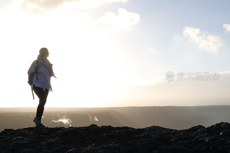 徒步旅行者在贫瘠的土地上走过岩石山脊