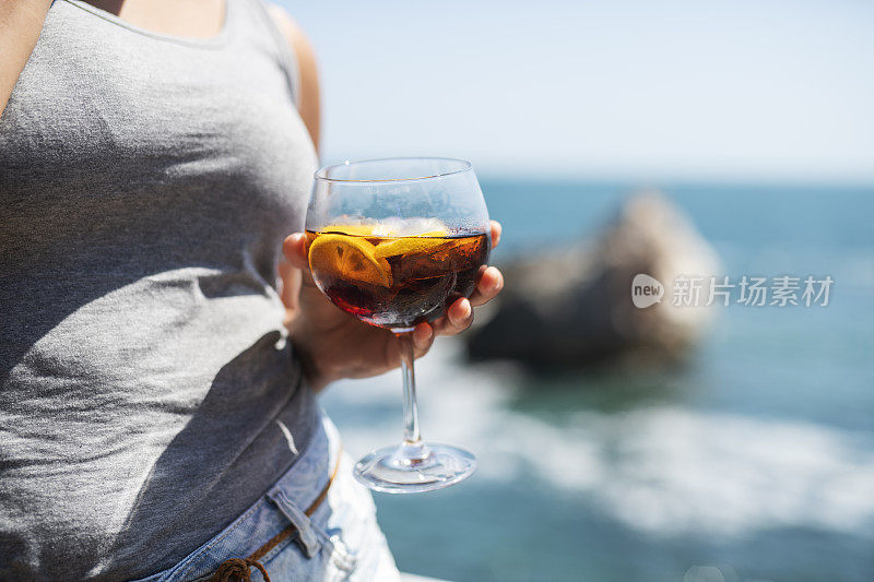 在海滩上喝夏日鸡尾酒的女人。