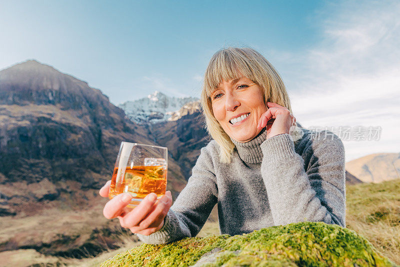 在苏格兰的格伦科，拿着一杯威士忌的女人