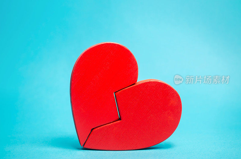 蓝色背景上的红色破碎的心。爱和关系。家庭心理治疗服务。和解。搜索后半部分。情人节。