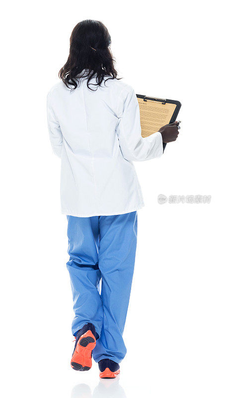 非裔美籍年轻女医生穿着实验服拿着文件走在白种人背景前