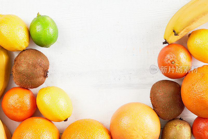 各种热带水果橙子，橘子，香蕉，葡萄柚，柠檬，酸橙，猕猴桃白色背景。