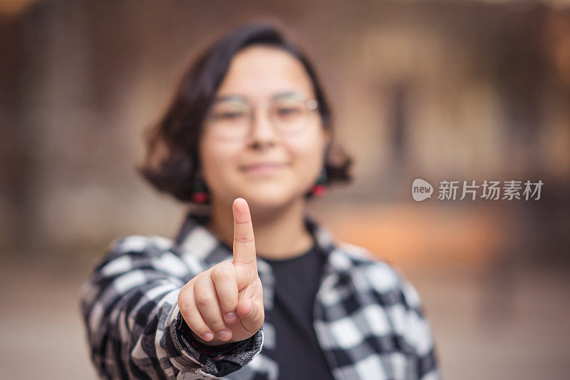 一个十几岁的女孩伸出食指