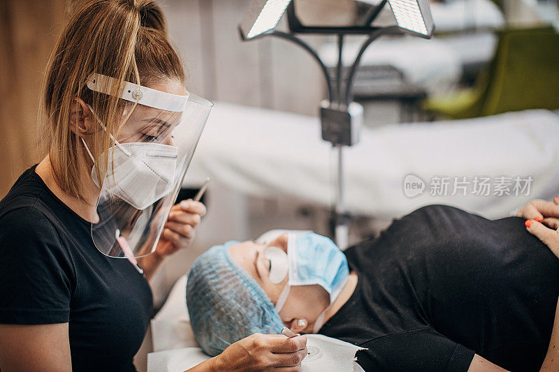 美容师带着防护面罩和护罩与病人见面