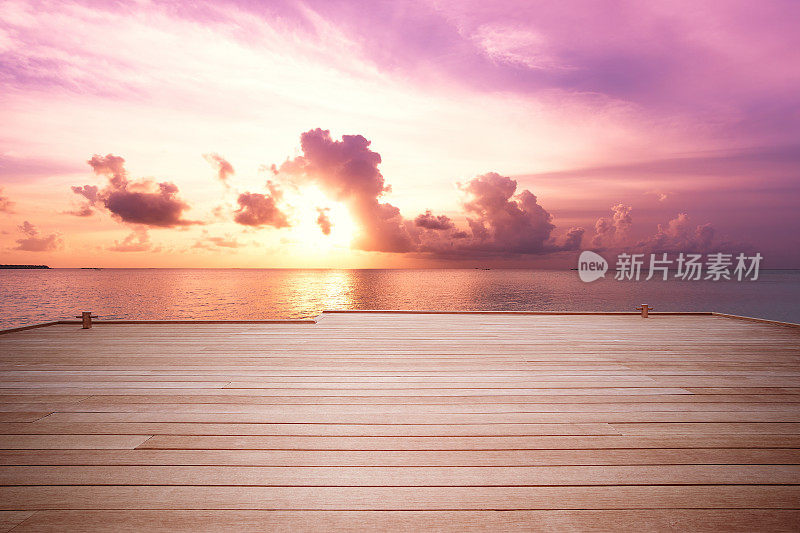 日落时分，马尔代夫热带海上的木桥码头。