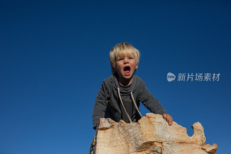 一个小男孩在南非塞德堡山的岩石上玩耍