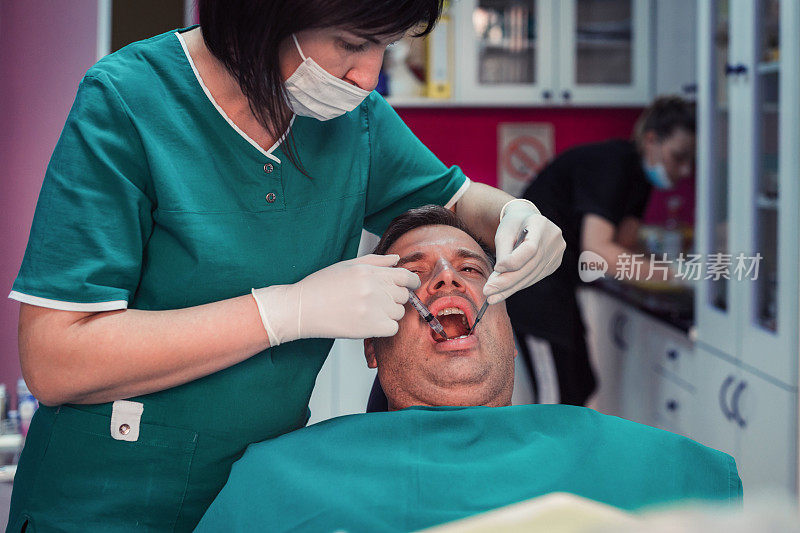 牙齿矫正医师照顾接受牙齿麻醉的病人