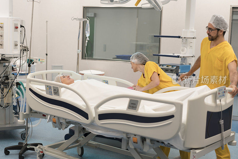 男女护士在手术室与病人一起调整轮床