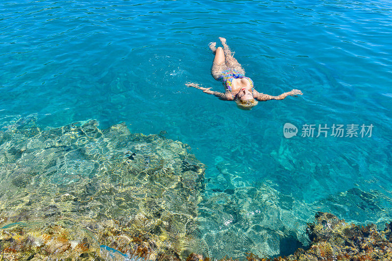 女人在海里愉快地游泳。