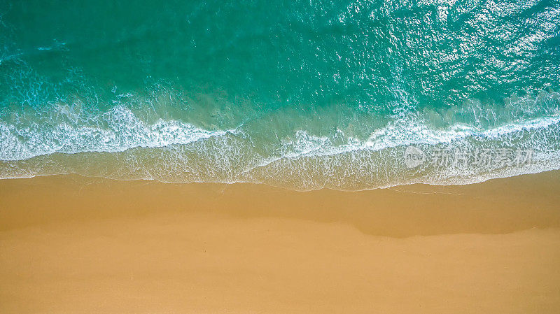 俯视图航拍图像从无人机一个惊人的美丽的海洋景观海滩绿松石水与复制空间为您的文本。美丽的沙滩与碧绿的海水，无人机无人机拍摄