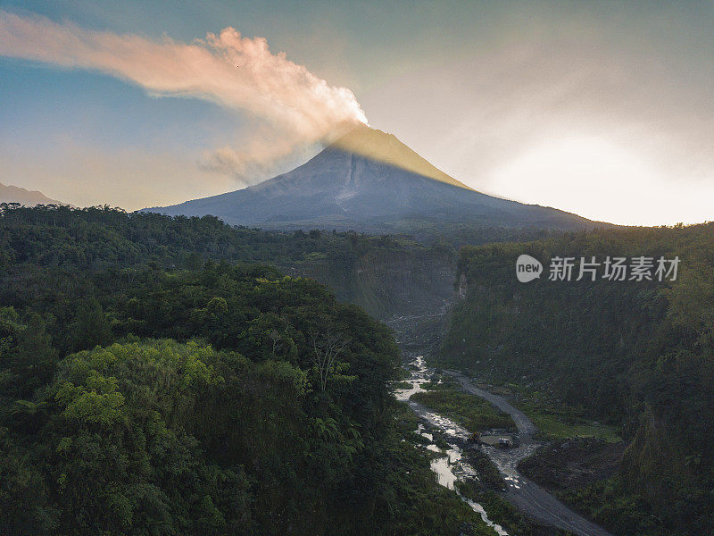 无人机拍摄的自然景观与河流和火山喷出的烟雾。熔岩流时，河流从悬崖上劈开。这座火山就是默拉皮火山