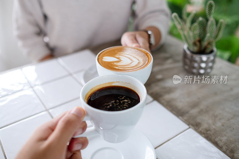 一对夫妇在咖啡馆里碰咖啡杯的特写照片