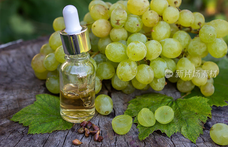 葡萄籽油玻璃罐和新鲜葡萄，用于水疗和身体护理。概念水疗、生物、生态产品。