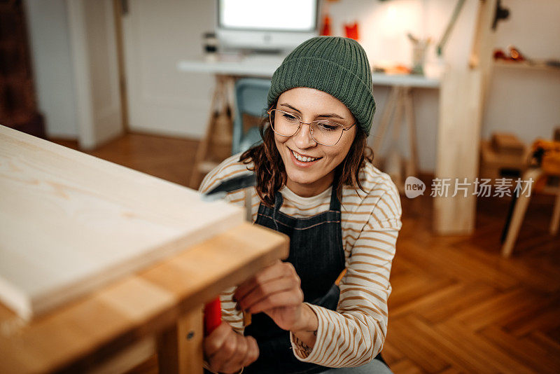 微笑的女商人在艺术工作室检查木材