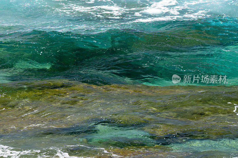 石灰石架与海洋生物通过水晶清澈的海水和波浪