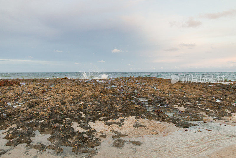 2022年10月，日落时分，海浪沿着佛罗里达州辛格岛空旷的岩石海滩海岸线飞溅