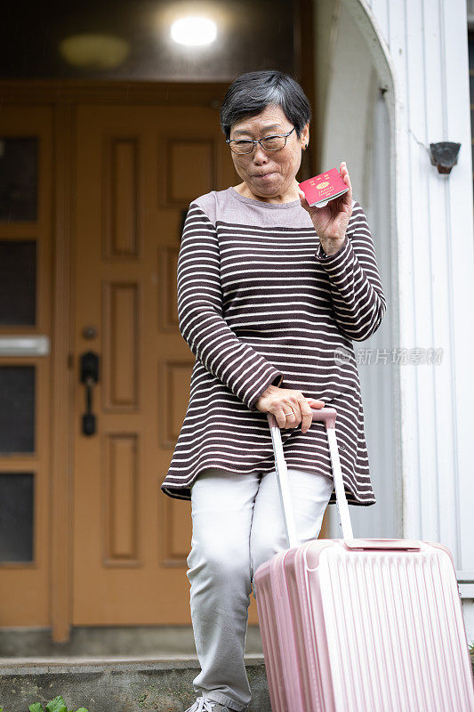 一位年长的日本妇女离开家准备旅行