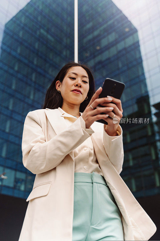 画像年轻的亚洲优雅的职业商业女性使用手机在办公室外发短信
