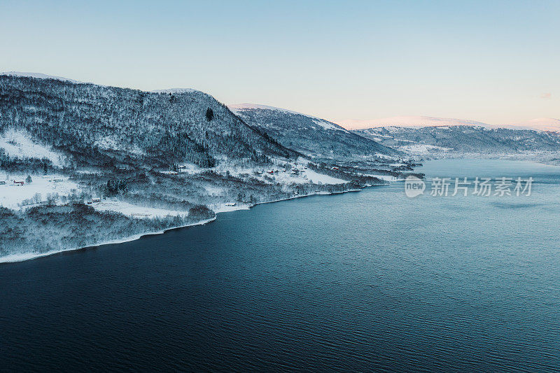 鸟瞰挪威湖泊和雪山上美丽的冬季日落