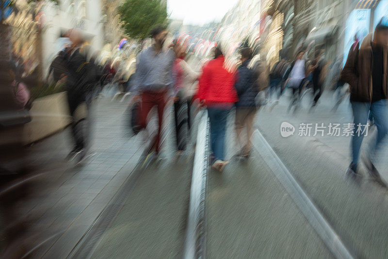 一群不知名的人走在繁忙的城市街道上
