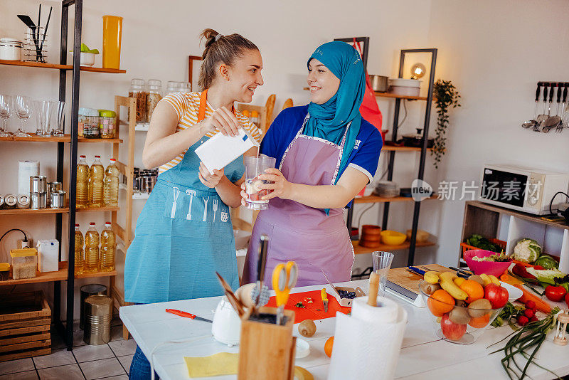 两个年轻的女人在家里准备健康的食物和饮料