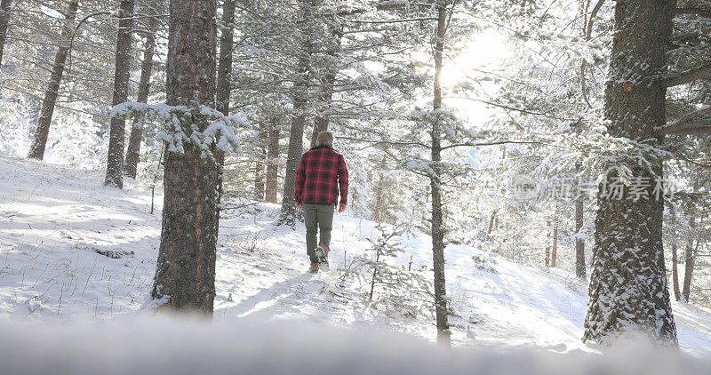 成熟的男人走在雪山小路上