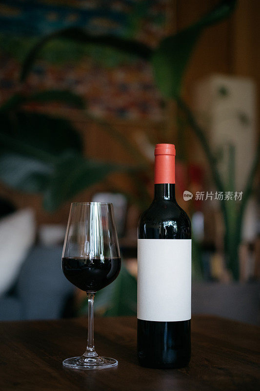 红色的酒杯和酒瓶，上面有空白的白色贴纸