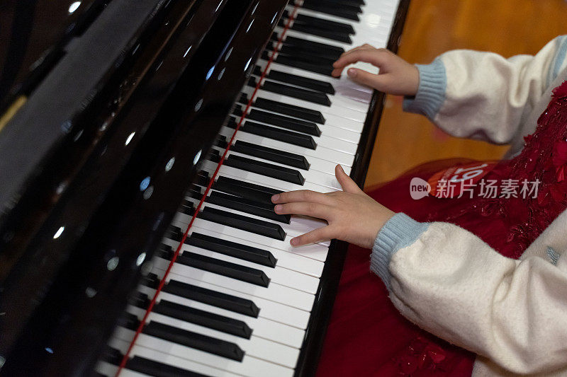 一个孩子的手放在钢琴上