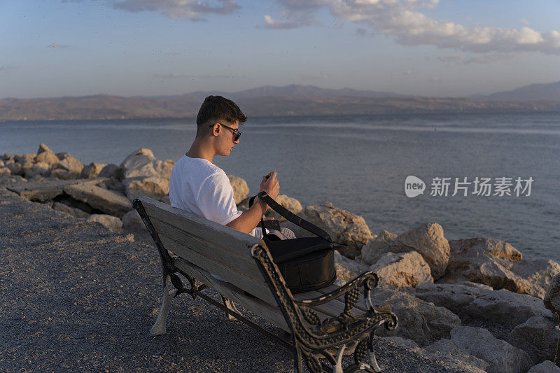 小男孩坐在海边。