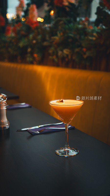 柑桔的幸福:橙色酒精鸡尾酒与白色泡沫和皮在餐厅的桌子上