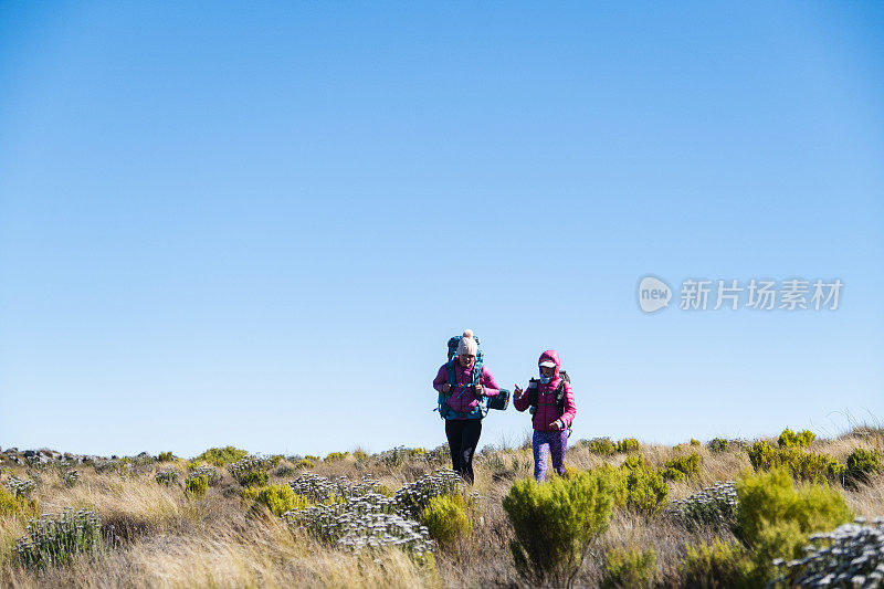 母亲和女儿在山上徒步旅行