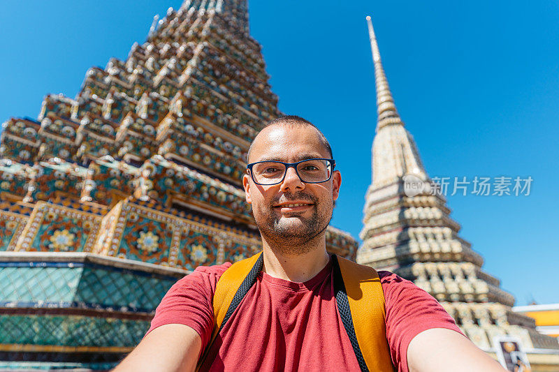 在泰国曼谷卧佛寺自拍的年轻人