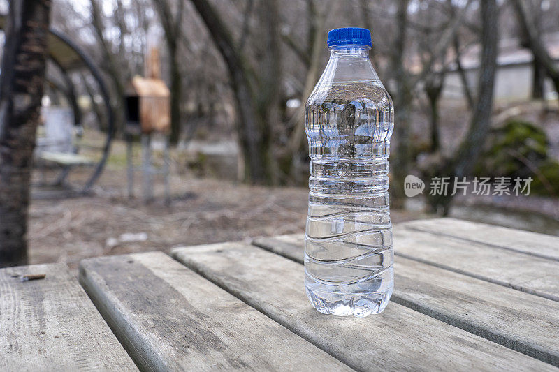 矿泉水瓶对抗光线和树木。