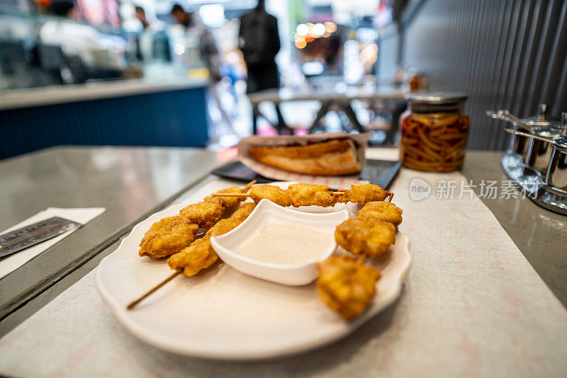 炒贻贝在餐桌上是街头食品的焦点，前景是街头，背景是横向的近距离零售