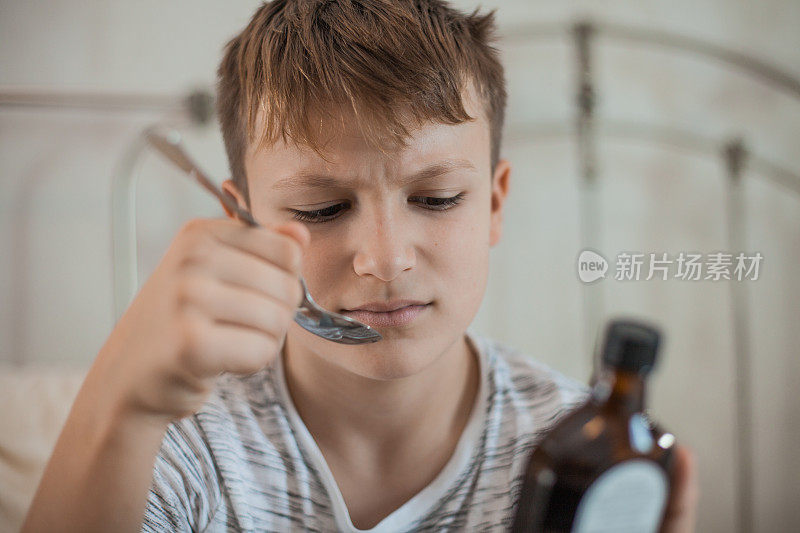 小男孩在吃止咳糖浆药