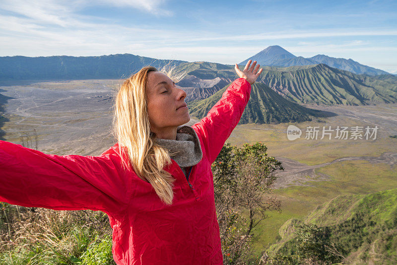 年轻的女人徒步旅行在印度尼西亚的Bromo火山上伸出双臂-人们旅行有趣的冒险概念成功和成就