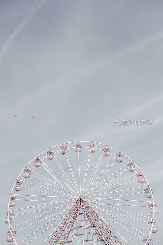 蓝色的天空和淡淡的白云白色，与一个空的摩天轮。