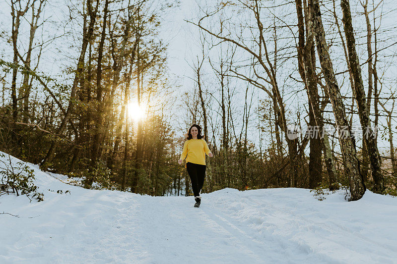 女人在雪地上蹦蹦跳跳