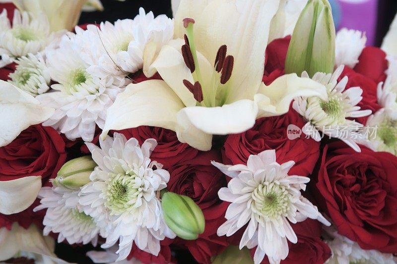 花台展示的是浪漫的白色和红色的婚礼花束，情人节的照片是红色的玫瑰，还有白色的百合，菊花，大丽花，以及以花朵、花蕾和花瓣为主题的芳香插花