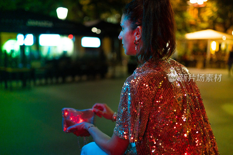 夜晚在大街上，穿着光彩照人的优雅女子