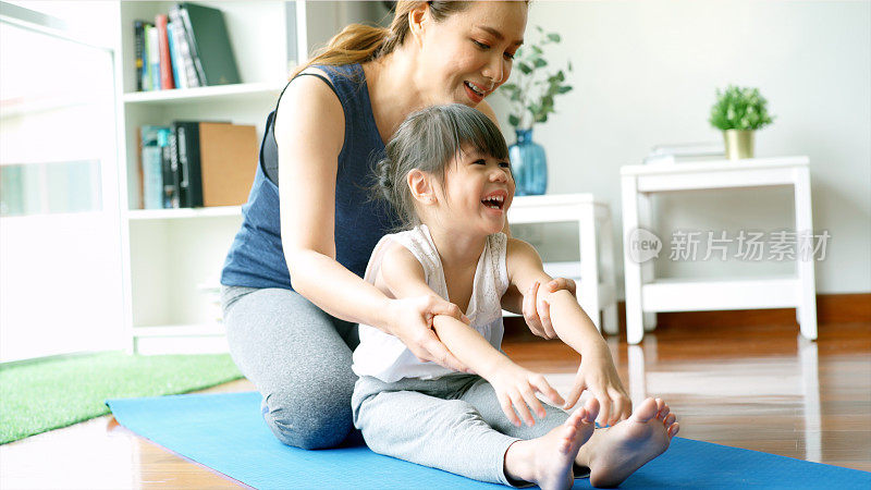 亚洲母亲练习瑜伽与她的女儿