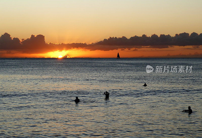 夏威夷日落时的冲浪者