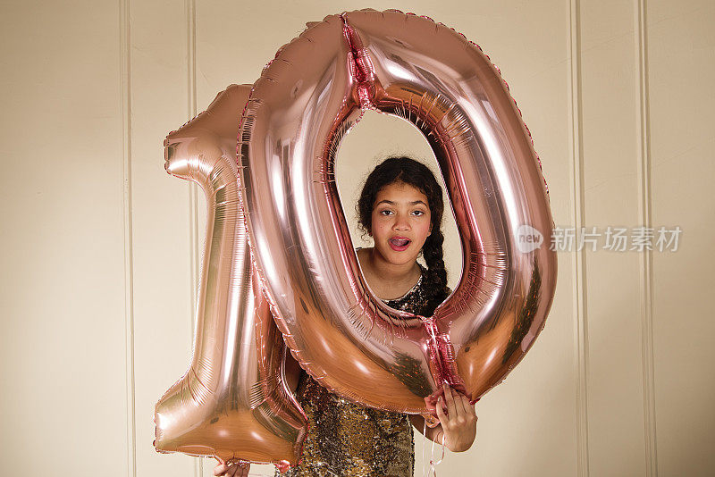 可爱的小女孩拿着气球庆祝十岁生日。