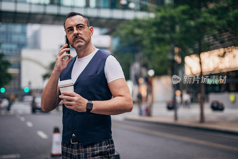 成熟优雅的男人正在一边喝咖啡一边打电话
