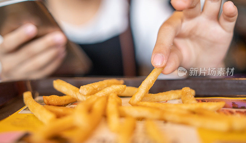 孩子手握炸薯条的特写