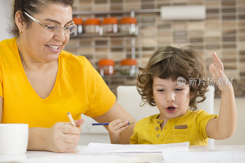 快乐的妈妈教她的小儿子如何写快乐的妈妈教儿子写和画