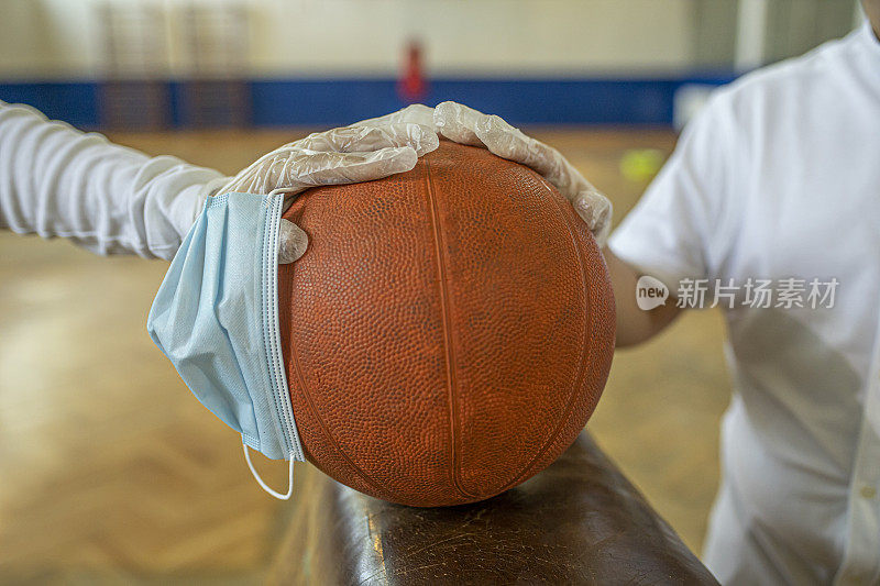 篮球和防护面罩。在健身房保持社交距离