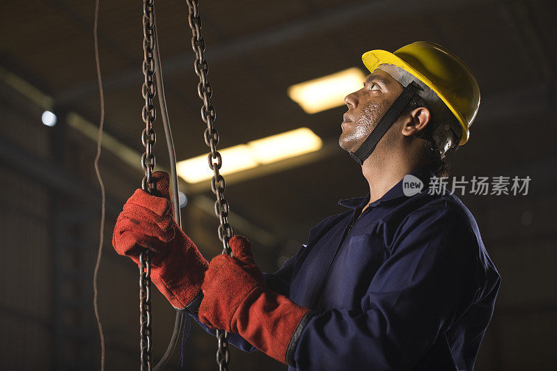 男工程师在工厂调整链葫芦