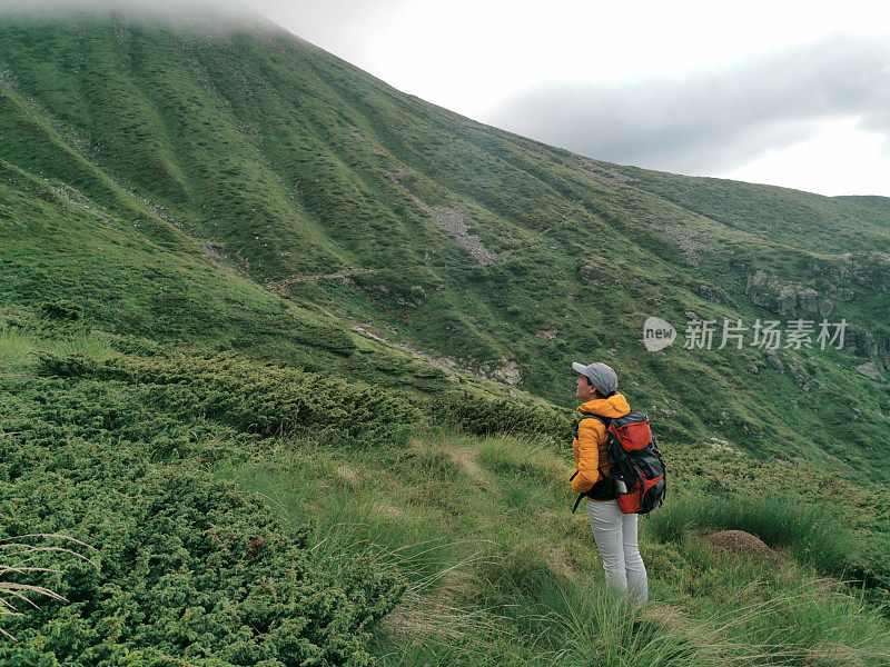 回归自然。独自在山里徒步旅行的女人。2019冠状病毒病大流行后阳光明媚的户外享受。