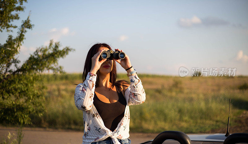 一个女人用双筒望远镜观察自然